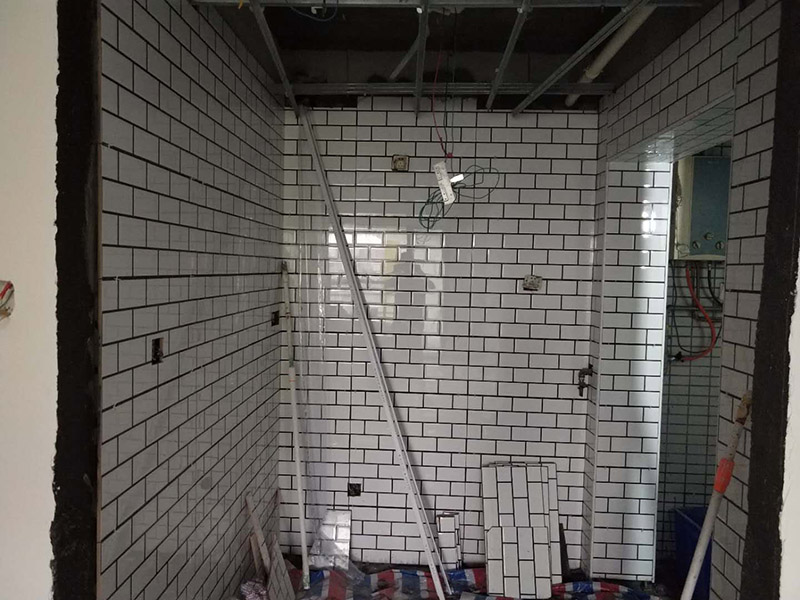 廁所裝修貼瓷磚案例：首先應(yīng)全部清理墻面上的各類污物，打掃干凈現(xiàn)場，特別是腳落里；然后用泥刀先批墻，后用水泥漿找平。這個(gè)工序很重要，確保底子平，防止貼后空鼓；以及墻面要刷防水涂料，防止貼后浸水，一般高度不低于1.8米，刷的時(shí)候會(huì)稍高一些；接著把粘結(jié)劑漿料均勻的刮到墻上，記得瓷磚上墻將經(jīng)過預(yù)先清潔的瓷磚平整地鋪貼在粘結(jié)劑漿料基層上，使用橡膠錘將瓷磚拍實(shí)鋪平。施工過程中，可小幅度轉(zhuǎn)動(dòng)瓷磚，使?jié){料與瓷磚背面充分接觸。