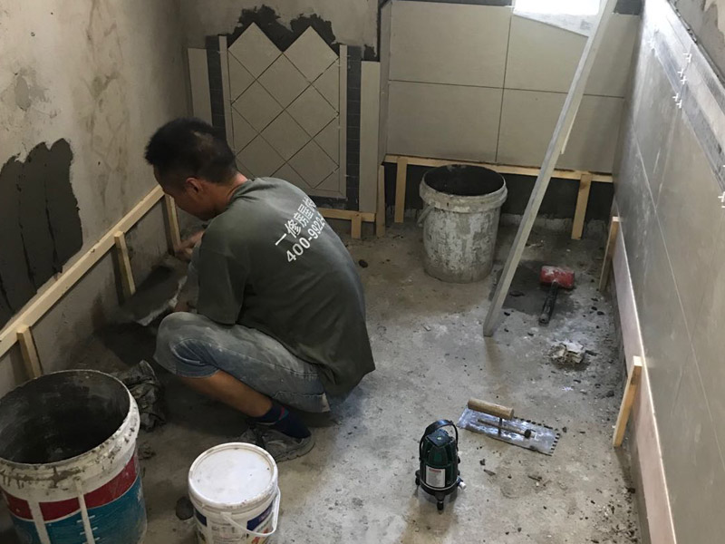 廁所瓷磚鋪貼裝修：首先應(yīng)除去基層表面的污垢，油漬，浮灰;除去基層上所有涂料層，膩子層;如果基層未能達(dá)到平整度要求，需對基層進(jìn)行預(yù)先的找平處理；鋪貼瓷磚前需事先找好垂直線，以此為基準(zhǔn)鋪貼的瓷磚高低均勻、垂直美觀;將調(diào)制好的漿料均勻地抹在瓷磚背面，要求漿料飽滿；將瓷磚平整地鋪貼在基層上，使用橡膠錘將瓷磚拍實鋪平。