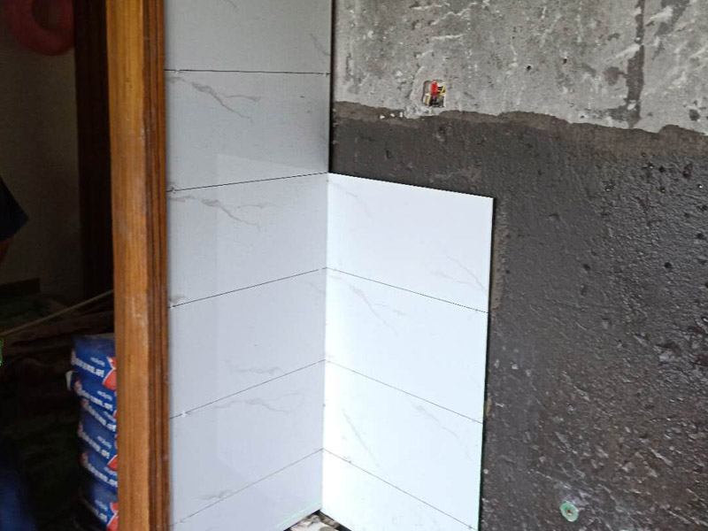 衛(wèi)生間墻面瓷磚鋪貼：首先應(yīng)除去基層表面的污垢，油漬，浮灰;除去基層上所有涂料層，膩子層;如果基層未能達到平整度要求，需對基層進行預(yù)先的找平處理；鋪貼瓷磚前需事先找好垂直線，以此為基準(zhǔn)鋪貼的瓷磚高低均勻、垂直美觀;將調(diào)制好的漿料均勻地抹在瓷磚背面，要求漿料飽滿；將瓷磚平整地鋪貼在基層上，使用橡膠錘將瓷磚拍實鋪平。