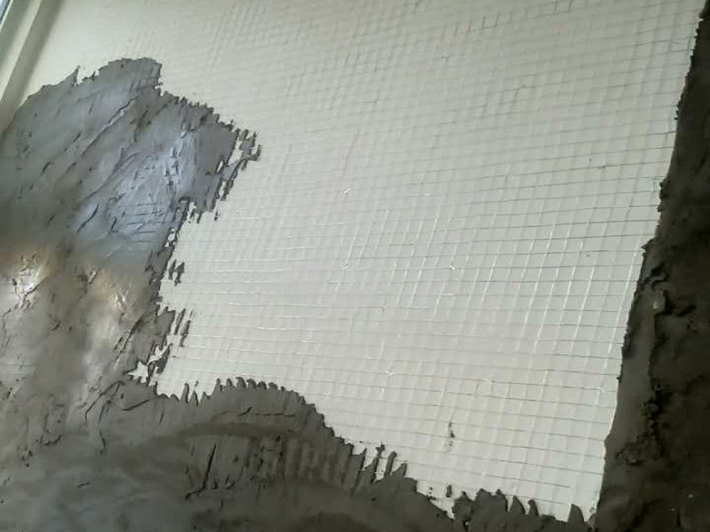 白灰墻面掛網(wǎng)抹灰裝修：1  基層處理：抹灰前檢查加氣混凝土墻體，對(duì)松動(dòng)、灰漿不飽滿的拼縫及粱、板下的頂頭縫，用摻用水量10%的建筑膠灰漿填塞密實(shí)。將露出墻面的舌頭灰刮凈，墻面的凸出部位剔鑿平整。墻面坑凹不平處、砌塊缺楞掉角的以及剔鑿的設(shè)備管線槽、洞，應(yīng)用膠灰整修密實(shí)、平順。2  灑水濕潤：將墻面浮土清掃干凈，分?jǐn)?shù)遍澆水濕潤。由于加氣混凝土塊吸水速度先快后慢，吸水量慢而延續(xù)時(shí)間長，故應(yīng)增加澆水的次數(shù)，使抹灰層有良好的凝結(jié)硬化條件，不致在砂漿的硬化過程中水分被加氣混凝土吸走。3  貼灰餅、沖筋：用托線板檢測一遍墻面不同部位的垂直、平整情況，以墻面的實(shí)際高度決定灰餅和沖筋的數(shù)量。