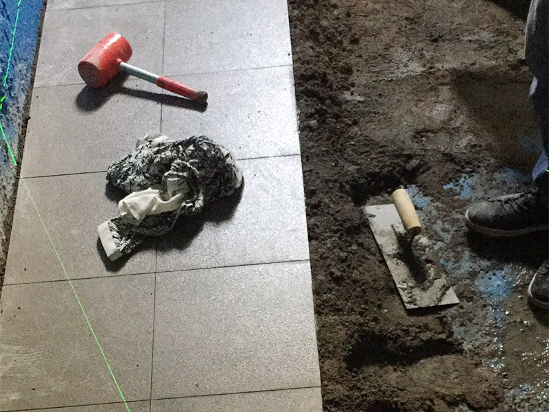 地面貼磚維修：干鋪法是將沙子和水泥按照3：1的比例混合后兌少量的水，使水泥和沙子混合到可以用手攥成團(tuán)的黏稠度。將混合好的沙子水泥鋪在地面上，用一個平板把表面摸平。在瓷磚背面抹上黏稠度非常高的水泥，把瓷磚放到地面上，用橡皮錘敲實就完成了,主要用于地面瓷磚的鋪裝.濕鋪法，是將沙子和水泥按照2：1的比例混合后兌水和好，水的量要多一些，使沙子和水泥的黏稠度高一些。然后涂抹到用水浸泡好的瓷磚背面貼到墻面上。濕鋪發(fā)主要應(yīng)用與墻面。