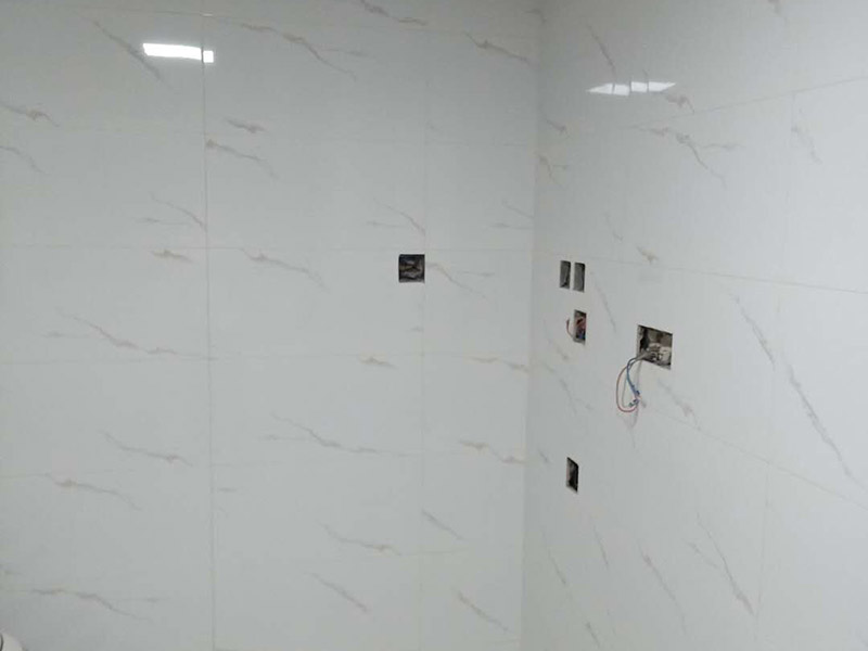 衛(wèi)生間瓷磚鋪貼：基層處理：把沾在基層上的浮漿、落地灰等用暫子或鋼絲刷清理掉，再用掃帚將浮土清掃干凈。找標(biāo)高：根據(jù)水平標(biāo)準(zhǔn)線(xiàn)和設(shè)計(jì)厚度，在四周墻、柱上彈出面層的上平標(biāo)高控制線(xiàn)。排磚：將房間依照磚的尺寸留縫大小，排出磚的放置位置，并在基層地面彈出十字控制線(xiàn)和分格線(xiàn)。鋪設(shè)結(jié)合層砂漿：鋪設(shè)前應(yīng)將基底濕潤(rùn)，并在基底上刷一道素水泥漿或界面結(jié)合劑，隨刷隨鋪設(shè)攪拌均勻的干硬性水泥砂漿。鋪磚時(shí)應(yīng)先在房間中間按照十字線(xiàn)鋪設(shè)十字控制磚，之后按照十字控制磚向四周鋪設(shè)，并隨時(shí)用2m靠尺和水平尺檢查平整度。大面積鋪貼時(shí)應(yīng)分段、分部位鋪貼。養(yǎng)護(hù)：當(dāng)磚面層鋪貼完24h內(nèi)應(yīng)開(kāi)始澆水養(yǎng)護(hù)，養(yǎng)護(hù)時(shí)間不得小于7d。