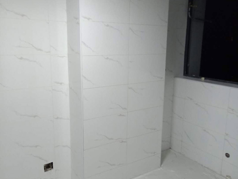 衛(wèi)生間瓷磚鋪貼：基層處理：把沾在基層上的浮漿、落地灰等用暫子或鋼絲刷清理掉，再用掃帚將浮土清掃干凈。找標(biāo)高：根據(jù)水平標(biāo)準(zhǔn)線(xiàn)和設(shè)計(jì)厚度，在四周墻、柱上彈出面層的上平標(biāo)高控制線(xiàn)。排磚：將房間依照磚的尺寸留縫大小，排出磚的放置位置，并在基層地面彈出十字控制線(xiàn)和分格線(xiàn)。鋪設(shè)結(jié)合層砂漿：鋪設(shè)前應(yīng)將基底濕潤(rùn)，并在基底上刷一道素水泥漿或界面結(jié)合劑，隨刷隨鋪設(shè)攪拌均勻的干硬性水泥砂漿。鋪磚時(shí)應(yīng)先在房間中間按照十字線(xiàn)鋪設(shè)十字控制磚，之后按照十字控制磚向四周鋪設(shè)，并隨時(shí)用2m靠尺和水平尺檢查平整度。大面積鋪貼時(shí)應(yīng)分段、分部位鋪貼。養(yǎng)護(hù)：當(dāng)磚面層鋪貼完24h內(nèi)應(yīng)開(kāi)始澆水養(yǎng)護(hù)，養(yǎng)護(hù)時(shí)間不得小于7d。