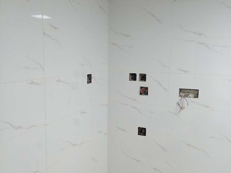 衛(wèi)生間瓷磚鋪貼：基層處理：把沾在基層上的浮漿、落地灰等用暫子或鋼絲刷清理掉，再用掃帚將浮土清掃干凈。找標(biāo)高：根據(jù)水平標(biāo)準(zhǔn)線(xiàn)和設(shè)計(jì)厚度，在四周墻、柱上彈出面層的上平標(biāo)高控制線(xiàn)。排磚：將房間依照磚的尺寸留縫大小，排出磚的放置位置，并在基層地面彈出十字控制線(xiàn)和分格線(xiàn)。鋪設(shè)結(jié)合層砂漿：鋪設(shè)前應(yīng)將基底濕潤(rùn)，并在基底上刷一道素水泥漿或界面結(jié)合劑，隨刷隨鋪設(shè)攪拌均勻的干硬性水泥砂漿。鋪磚時(shí)應(yīng)先在房間中間按照十字線(xiàn)鋪設(shè)十字控制磚，之后按照十字控制磚向四周鋪設(shè)，并隨時(shí)用2m靠尺和水平尺檢查平整度。大面積鋪貼時(shí)應(yīng)分段、分部位鋪貼。養(yǎng)護(hù)：當(dāng)磚面層鋪貼完24h內(nèi)應(yīng)開(kāi)始澆水養(yǎng)護(hù)，養(yǎng)護(hù)時(shí)間不得小于7d。