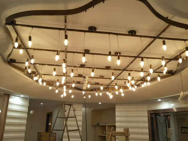 大型吊燈安裝：首先大致尺寸要測量好，確定位置；然后石膏板上鉆孔，然后埋設(shè)鐵件五金配件或者木條，用黏貼劑或者水泥漿將空洞的周邊補(bǔ)齊，等到差不多干燥了再接下來做。接著把鐵件或者木條固定，這是吊燈安裝的重要步驟，如果沒有固定好，使用壽命會(huì)受到影響。電線通過吊桿引入到燈芯里面，如果配套燈帶使用開關(guān)的，穿線的時(shí)候要注意線路的走向。最后就是燈罩、燈臂的安裝。用看、螺絲刀等工具將燈罩組裝好，安裝好后，通電試試就可以了，根據(jù)實(shí)際情況稍微調(diào)整下。