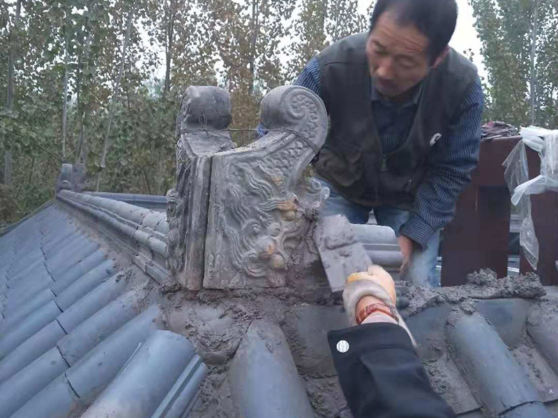 屋頂裝飾瓦安裝：做仿古瓦屋脊一般有三種方法：第一、像作平瓦屋脊一樣，將瓦一片一片地從一個山頭鋪筑到另一個山頭;第二、將瓦片斜成一定的角度并擠緊，有山頭向中間筑脊;第三、先在兩山頭各平放一疊瓦封頭。具體做脊時(shí)，一般先在靠近屋脊兩邊的坡屋面上先鋪筑5-6張仰瓦作為分垅的標(biāo)準(zhǔn)，屋脊筑完成后用混合砂漿或紙筋灰將屋脊背及瓦垅的縫堵塞密實(shí)、壓緊抹光。