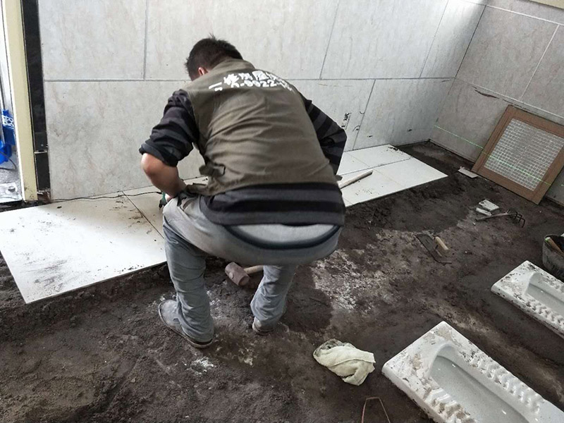 公廁貼磚維修：基層處理：應(yīng)全部清理墻面上的各類污物，打掃干凈現(xiàn)場，特別是腳落里。 批墻、墻面找平：用泥刀先批墻，后用水泥漿找平。這個工序很重要，確保底子平，防止貼后空鼓。 刷防水涂料：墻面要刷防水涂料，防止貼后浸水，一般高度不低于1.8米，刷的時候會稍高一些。 找水平基準(zhǔn)線：根據(jù)設(shè)計鋪貼圖樣的要求，確定排磚方案，用墨斗彈線，以減少施工損耗。 粘結(jié)劑上墻：把剛剛攪拌好的粘結(jié)劑漿料均勻的刮到墻上。 瓷磚上墻將經(jīng)過預(yù)先清潔的瓷磚平整地鋪貼在粘結(jié)劑漿料基層上，使用橡膠錘將瓷磚拍實鋪平。施工過程中，可小幅度轉(zhuǎn)動瓷磚，使?jié){料與瓷磚背面充分接觸。專家建議在鋪貼時，隨機取下已鋪貼于基層上的瓷磚作檢查。確保漿料與瓷磚背面的充分接觸。 留縫大小調(diào)整根據(jù)瓷磚的尺寸，在磚與磚之間預(yù)留相應(yīng)尺寸的縫隙留待嵌縫?？捎醚篮灥认裙潭ǎ辰Y(jié)劑具有一定的可調(diào)整性，可對留縫的大小進行調(diào)整。