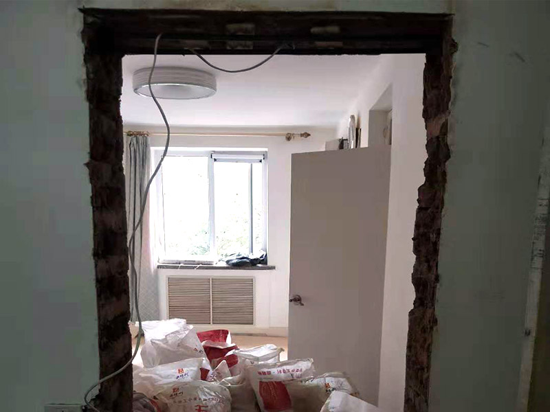 墻面開門洞：把砸去400mm高，寬2340mm的墻，全部用鋼筋混凝土澆筑。內(nèi)配上下各3根直徑12mm的帶肋鋼筋，箍筋直徑6mm，間距200mm，扎好鋼筋放上。支模，注意一側(cè)模板要支成◢形，高度為450，混凝土從該斜口倒入澆筑與斜口平，已高出了圈梁底50mm，即能使其與圈梁底充分咬合。拆模把多余部分鑿除。 應(yīng)在過梁部位先開洞做好過梁，再開門洞，每邊大于100mm，植2根10個鋼筋交門邊柱作為門垛。鋼筋混凝土過梁在普通磚墻上擱置長度應(yīng)不小于24cm,也就是一磚的厚度，而實際上門口是38墻，所以過梁一般是38cm； 門洞墻體高建議敲頂部梁面鑿洞再皮皮敲兩邊敲凹凸狀部做梁再砌筑面墻體直接底洞容易整版墻敲壞松玩且能塌肯定玩洞直接鉆洞。