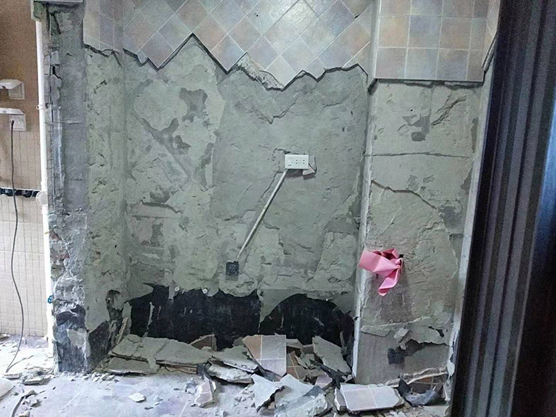 廚房拆除施工：墻面上應(yīng)該還有些其他東西，比如掛毛巾的架子，放廚具的架子等等。先把這些物品都小心翼翼的拆下來，還原一面光潔的墻面，才好進(jìn)行拆卸工作。先用垂子敲最下面的那塊磚，把瓷磚敲松動(dòng)。送動(dòng)后，再用戴了手套的手把瓷磚拿下來，小心碎了瓷磚不要?jiǎng)澋绞至恕γ鎯?nèi)有些地方會(huì)走一些管道，有煤氣管道，有電線管道，水管，網(wǎng)線等等。要注意這些管道，不要把墻里面的管道破壞了，不然拆了瓷磚又惹了新的問題要處理。拆卸下來的瓷磚堆積在地上很不方便繼續(xù)工作，這個(gè)時(shí)候上面提到的推車就派上用場(chǎng)了。用推車把瓷磚運(yùn)走，清理干凈現(xiàn)場(chǎng)，然后繼續(xù)拆卸，直到整面的墻面都拆卸完整。