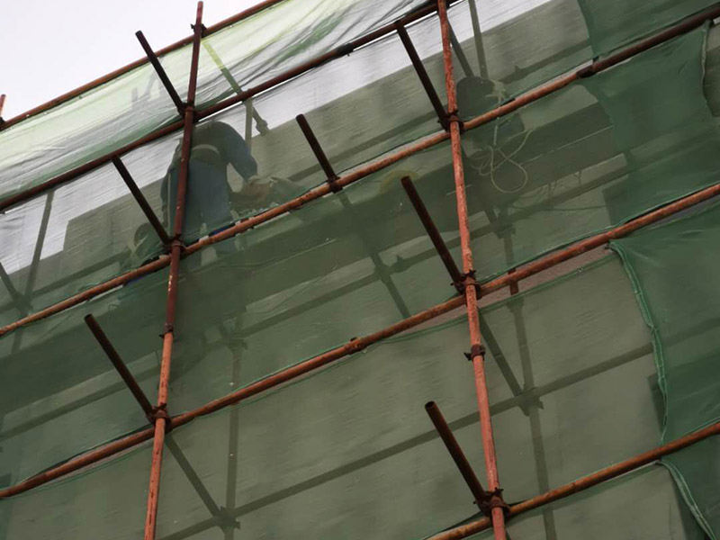 高空外墻防水：首先清理基層，新舊面層必須清理干凈，不得有雜物和灰塵，以免影響粘結(jié)強度，涂刷防水涂料時基層應干燥。接下來，清理死角，也就是所謂的陰陽角、施工縫、伸縮縫等比較重要的部位進行處理，尤其注意的是泄水孔要加強處理，需要涂刷2-3遍防水底層涂料。備好防水卷材、防水涂料、基層涂料和粘接卷材的涂料必須要分清，為提高防水卷材與基層粘結(jié)性，可用底層涂料反復涂刷，涂刷均勻，覆蓋完全，充分滲入混凝土基層，以提高粘結(jié)強度和抗剪切強度。涂刷第二次涂料之前必須要等第一次涂料完全凝固后方可再次涂刷，底層涂料第一次涂刷完畢后約4-8小時左右，方可再次涂刷第二次和第三次底層涂料。