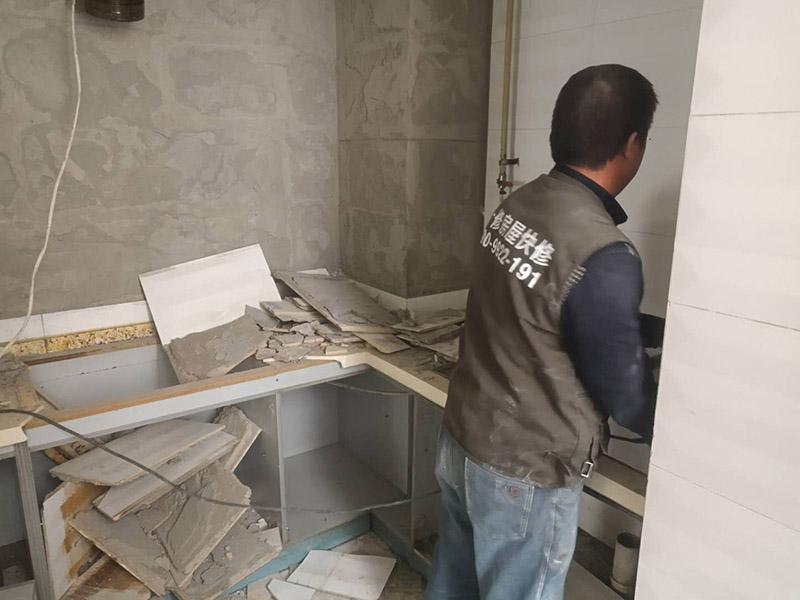 廚房瓷磚拆除：墻面上應(yīng)該還有些其他東西，比如掛毛巾的架子，放廚具的架子等等。先把這些物品都小心翼翼的拆下來，還原一面光潔的墻面，才好進(jìn)行拆卸工作。拆卸的時候要先從墻低的第一塊磚開始拆卸，要是直接隨便從上面那一塊拆卸，拆到一半就會擋住下面的瓷磚，讓下面的瓷磚不好拆了。先用垂子敲最下面的那塊磚，把瓷磚敲松動。送動后，再用戴了手套的手把瓷磚拿下來，小心碎了瓷磚不要劃到手了。拆卸下來的瓷磚堆積在地上很不方便繼續(xù)工作，這個時候上面提到的推車就派上用場了。用推車把瓷磚運走，清理干凈現(xiàn)場，然后繼續(xù)拆卸，直到整面的墻面都拆卸完整。