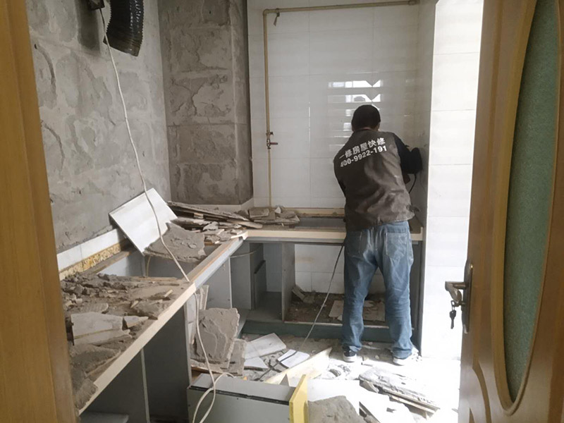 廚房瓷磚拆除：墻面上應(yīng)該還有些其他東西，比如掛毛巾的架子，放廚具的架子等等。先把這些物品都小心翼翼的拆下來，還原一面光潔的墻面，才好進(jìn)行拆卸工作。拆卸的時候要先從墻低的第一塊磚開始拆卸，要是直接隨便從上面那一塊拆卸，拆到一半就會擋住下面的瓷磚，讓下面的瓷磚不好拆了。先用垂子敲最下面的那塊磚，把瓷磚敲松動。送動后，再用戴了手套的手把瓷磚拿下來，小心碎了瓷磚不要劃到手了。拆卸下來的瓷磚堆積在地上很不方便繼續(xù)工作，這個時候上面提到的推車就派上用場了。用推車把瓷磚運走，清理干凈現(xiàn)場，然后繼續(xù)拆卸，直到整面的墻面都拆卸完整。