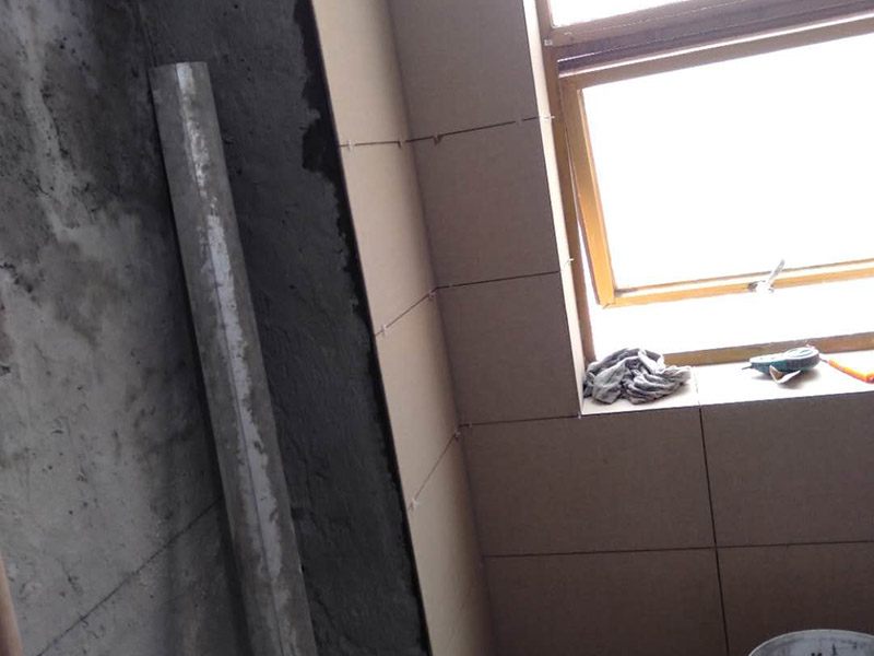 墻面貼磚施工：干鋪法是將沙子和水泥按照3：1的比例混合后兌少量的水，使水泥和沙子混合到可以用手攥成團(tuán)的黏稠度。將混合好的沙子水泥鋪在地面上，用一個(gè)平板把表面摸平。在瓷磚背面抹上黏稠度非常高的水泥，把瓷磚放到地面上，用橡皮錘敲實(shí)就完成了,主要用于地面瓷磚的鋪裝。 濕鋪法，是將沙子和水泥按照2：1的比例混合后兌水和好，水的量要多一些，使沙子和水泥的黏稠度高一些。然后涂抹到用水浸泡好的瓷磚背面貼到墻面上。濕鋪發(fā)主要應(yīng)用與墻面。