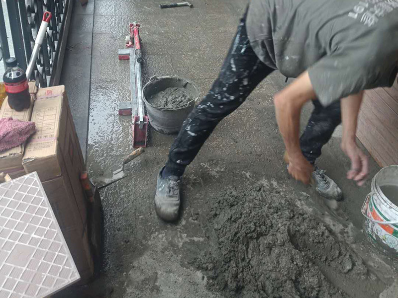 入戶門地磚鋪貼：要在地面刷一遍水泥和水比例為0.4&mdash;0.5的素水泥水。然后鋪上1：3的砂漿，砂漿要干濕適度，標(biāo)準(zhǔn)是&ldquo;手握成團(tuán)，落地開花&rdquo;，砂漿攤開鋪平把地磚鋪在砂漿上，用橡皮錘敲打結(jié)實(shí)和第一塊基準(zhǔn)磚平齊。敲打結(jié)實(shí)后，拿起瓷磚，看砂漿是否有欠漿或不平整的地方，撒上砂漿補(bǔ)充填實(shí)。第二次把瓷磚鋪上，敲打結(jié)實(shí)至和基準(zhǔn)磚平齊。檢查地面砂漿是否已經(jīng)飽滿，有沒有縫隙，如果已經(jīng)飽滿和平整，在瓷磚上均勻地涂抹一層素水泥漿。用刮刀從磚縫中間劃一道，保證磚與磚之間要有一定的、均勻的縫隙，防止熱脹冷縮對磚造成損壞，用刮刀在兩塊磚上縱向來回劃拉，檢查兩塊磚是否平齊。