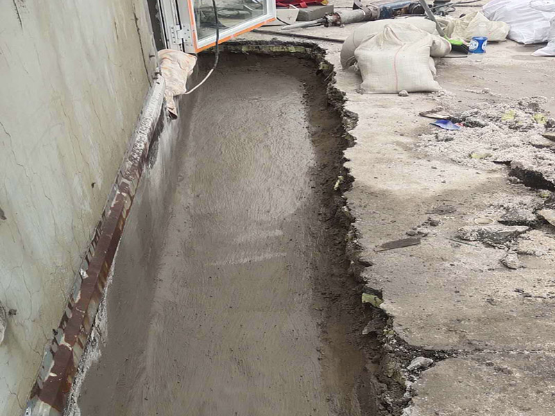 墻壁滲水維修：清理裂縫上及周邊的灰塵等垃圾（可用清潔球等清理），發(fā)現(xiàn)裂縫周邊有松動(dòng)的應(yīng)鑿除，并用水徹底沖刷干凈。 用普通水泥（不用加黃砂，為配合外墻面原有真石漆顏色，可在水泥中適量加入黃粉、哈巴粉等顏料，適量進(jìn)行調(diào)配，盡量接近原有真石漆面層顏色），再加上建筑用881等膠水（不用加水），直接進(jìn)行調(diào)配。(膠水用量不大，盡量使用好些，如使用貼石膏線的，價(jià)格誤差不大)，可根據(jù)天氣溫度等情況來(lái)調(diào)配水泥漿的稠度，填縫的可適當(dāng)稀些。 施工時(shí)應(yīng)先進(jìn)行填縫施工、縫必須灌實(shí)，在縫填實(shí)后需擴(kuò)大縫一邊寬30mm左右，厚約6mm的同材料面層，形成坡比（塌邊）。 在窗角處的裂縫，可把調(diào)配好的水泥漿做成半徑30-50mm的圓弧形，來(lái)增加裂縫處的厚度，同時(shí)有利于排水。 待水泥硬化（干燥后）進(jìn)行防水劑施工，涂刷需2遍，不得有遺漏。