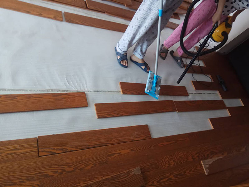 客廳木地板鋪貼：首先大家應(yīng)對(duì)是施工地進(jìn)行清理，把無(wú)關(guān)的東西都移出去，并且把地面上的垃圾清掃干凈，包括每一個(gè)角落。然后對(duì)地面進(jìn)行找平，水平誤差不能超過(guò)2mm，超過(guò)的話就要想辦法找平了。地面要是不平，地板鋪好后腳感當(dāng)然也就不好了。 木地板遇潮后易起拱、變形,為了避免這種情況,大家需要對(duì)地面進(jìn)行防潮處理。常見(jiàn)的處理方法是在地面上鋪防潮層，這樣可以防止以后地板受潮。防潮層要鋪平，接縫處要并攏。 為了讓地板鋪出來(lái)的效果更加的美觀，大家最好先預(yù)鋪下，將部分地板一分為二，要根據(jù)尺寸來(lái)鋸，萬(wàn)一鋸多了，地板損耗就大了。在鋸地板前可以將地板全部打開(kāi)包，挑出有問(wèn)題或瑕疵的地板來(lái)鋸，這樣可以有效將局部有問(wèn)題的地板充分利用，不產(chǎn)生過(guò)大損耗。千萬(wàn)不要上來(lái)就拿好地板來(lái)鋸，那會(huì)增加損耗的。鋸地板的地點(diǎn)務(wù)必要選在陽(yáng)臺(tái)等有瓷磚好打理衛(wèi)生的地方，否則飛濺的木灰會(huì)無(wú)孔不入的進(jìn)入任何地方，很難清潔。