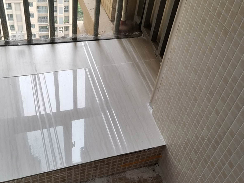 陽臺瓷磚鋪貼：準(zhǔn)備粘結(jié)劑前，瓷磚不應(yīng)浸水，但要用鋼絲刷除去磚背面的松散物質(zhì)，并用濕布抹去磚背的浮塵。然后按照生產(chǎn)商建議的比例將水或乳液放到攪拌桶中攪拌直至粘結(jié)劑均勻無結(jié)塊。初始攪拌后的粘結(jié)劑應(yīng)靜置在攪拌桶中，直到生產(chǎn)商推薦的熟化時間過后攪拌一下再使用。 在鋪壓瓷磚前，在瓷磚背面也批一薄層粘結(jié)劑。這種雙批法雖然用的材料和工時比較多，但卻能夠保證粘貼的質(zhì)量和耐久性。 在粘結(jié)劑量置晾時間內(nèi)，將準(zhǔn)備好的瓷磚鋪壓到位，垂直于梳理方向輕微搓動以排出磚下的空氣。鋪貼到位后用橡皮錘輕擊，用尺寸合適的十字定位架來調(diào)整表面平整度及接縫的平直。