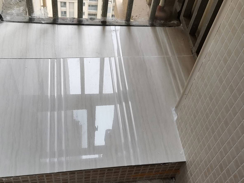 陽臺瓷磚鋪貼：準(zhǔn)備粘結(jié)劑前，瓷磚不應(yīng)浸水，但要用鋼絲刷除去磚背面的松散物質(zhì)，并用濕布抹去磚背的浮塵。然后按照生產(chǎn)商建議的比例將水或乳液放到攪拌桶中攪拌直至粘結(jié)劑均勻無結(jié)塊。初始攪拌后的粘結(jié)劑應(yīng)靜置在攪拌桶中，直到生產(chǎn)商推薦的熟化時間過后攪拌一下再使用。 在鋪壓瓷磚前，在瓷磚背面也批一薄層粘結(jié)劑。這種雙批法雖然用的材料和工時比較多，但卻能夠保證粘貼的質(zhì)量和耐久性。 在粘結(jié)劑量置晾時間內(nèi)，將準(zhǔn)備好的瓷磚鋪壓到位，垂直于梳理方向輕微搓動以排出磚下的空氣。鋪貼到位后用橡皮錘輕擊，用尺寸合適的十字定位架來調(diào)整表面平整度及接縫的平直。