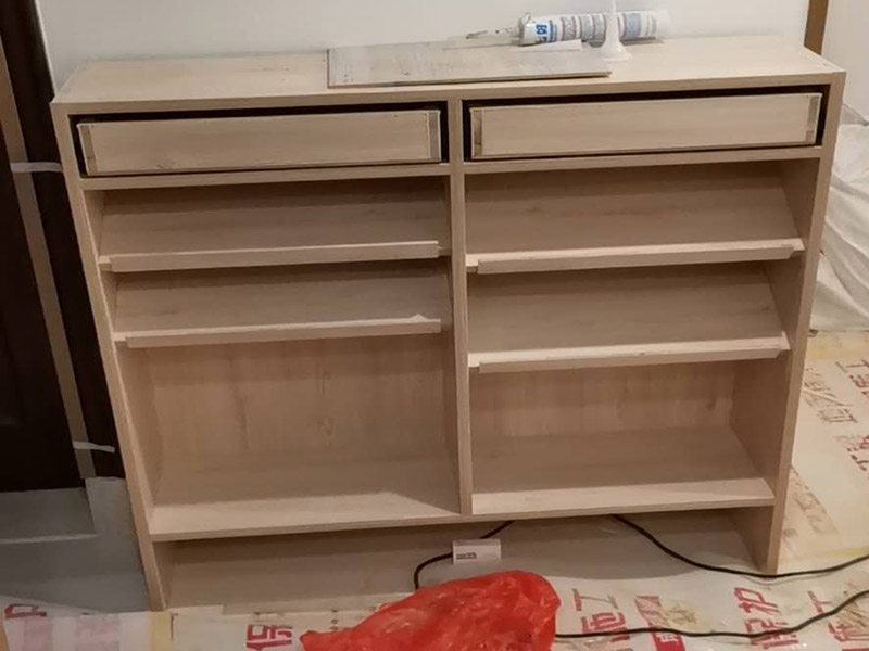 家具柜體安裝：用墊布點(diǎn)好地板，先從靠墻的一端寬du側(cè)板開始組裝，將寬側(cè)板平放于地面上(離后墻面保持700mm間隔)。首先將填好的三合一膠塞的板件，平放在墊布上，檢查孔距與圖紙相符，并裝上三合一單連桿。然后將固層釘上木塞，固定于寬側(cè)板上面，頂板大柄孔朝上，其余固層都朝下，腳線大柄孔朝內(nèi)(中間固層與L架高度一致，即底板到固層內(nèi)空為960mm，現(xiàn)場打?qū)影蹇?。放上側(cè)板，釘上木塞，木塞要求連通兩邊的固層。在第二個(gè)柜固層上面裝好雙連桿，留意雙連桿上面大柄只能鎖住一半，即90&deg;。當(dāng)兩件固層與側(cè)板固定后再同時(shí)擰緊大柄。 釘背板：把裝好的整體柜側(cè)放在點(diǎn)好墊布的地板上面，墊平側(cè)板成統(tǒng)一平面。用拉尺量好柜子的對(duì)角尺寸，調(diào)至相等，從寬測板處開始裝第一塊背板，留意假如中間有固層釘釘子時(shí)，先用鉛筆畫好固層的中央線，再釘釘子。