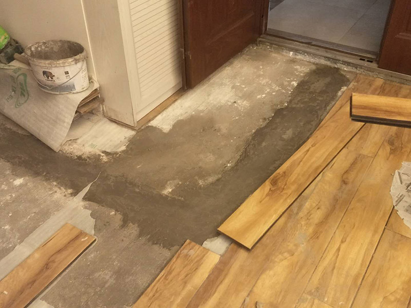 入戶門鋪地板：1、先對地面進行找平，水平的誤差不能超過2毫米。地面要是不平，腳感就不好。再就是將邊、角部位等突起或有不平的地方進行局部修整。再鋪防潮層，防潮層可以防止以后地板受潮。鋪平，接縫處要并攏。  2、然后就是安裝地板了，因為地板是要錯落安裝的，先預(yù)鋪一下，將部分地板一分為二，要按尺寸來鋸，萬一鋸多了，地板損耗就大了。因為地板有一定的膨脹率，因此鋪裝前要在其與墻面接觸的部位預(yù)留膨脹縫，以免地板起鼓。膨脹縫的大小一般和地板的膨脹系數(shù)有關(guān)系。粘合地板的膠水要用強化地板專用的，這種膠的污染比較小。不要隨便在市場上選非地板專用膠，地板本身就存在的污染上再增加污染源。  3、鋪前看好地板是否用對，再鋪設(shè)地板。在鋪設(shè)時，要一塊短的旁邊鋪一塊長的，這樣交叉鋪設(shè)地板就咬得住不易松動，地板拼合后還要用工具敲緊。再下來就是銜接了，一般用地板壓條掩蓋。但也有用玻璃膠填充。