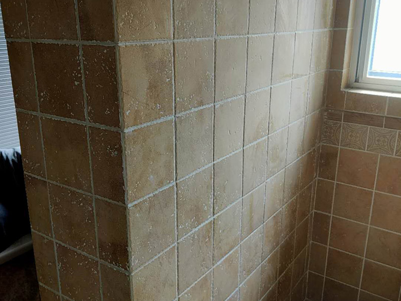 墻面瓷磚鋪貼：（1）基層處理：將塵土、雜物徹底清掃干凈，不得有空鼓、開裂及起砂等缺陷。 （2）彈線：施工前在墻體四周彈出標(biāo)高控制線，在地面彈出十字線，以控制地磚分隔尺寸。 （3）鋪貼：鋪設(shè)選用1：3干硬性水泥砂漿，砂漿厚度25mm左右。鋪貼前將地磚背面濕潤，需正面干燥為宜。把地磚按照要求放在水泥砂漿上，用橡皮錘輕敲地磚飾面直至密實(shí)平整達(dá)到要求。 （4）勾縫：地磚鋪完后24h進(jìn)行清理勾縫，勾縫前應(yīng)先將地磚縫隙內(nèi)雜質(zhì)擦凈，用專用填縫劑勾縫。 （5）清理：施工過程中隨干隨清，完工后(一般宜在24h之后)再用棉紗等物對(duì)地磚表面進(jìn)行清理。