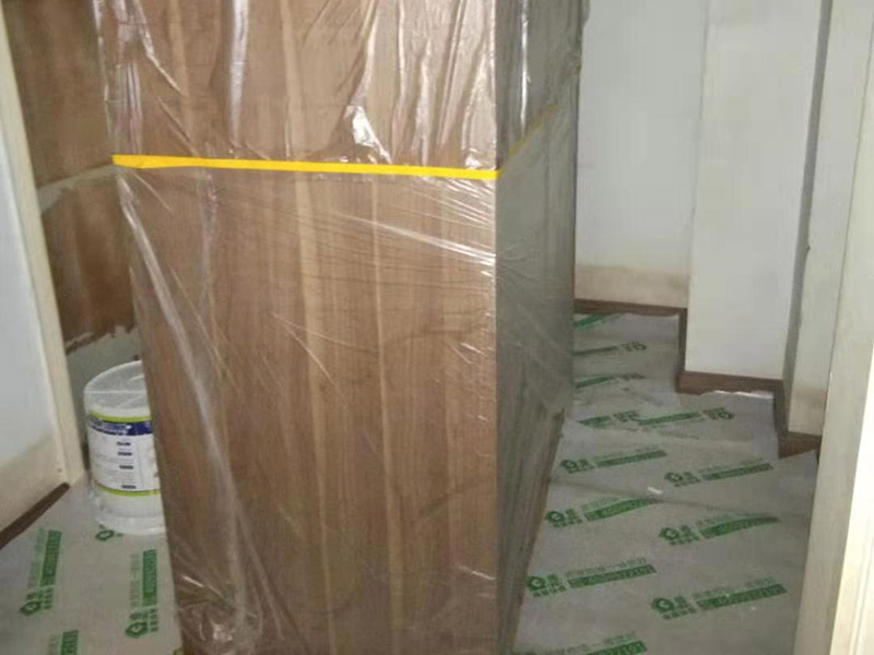 全屋家具成品保護：滿鋪成品瓦楞紙板，再用干凈彩條布滿鋪在普通石膏板上，在彩條布交接處及轉(zhuǎn)角處用膠帶固定，也可選用木芯板或三夾板。材料選用視上人、車情況而定。 所有成品飾面板在安裝好后必須用PE保護膜覆蓋包起來，所有成品飾面板的陽角位必須用硬質(zhì)紙護角或泡沫棉進行保護性包裝，防止交被其他施工人員碰撞。 1、入戶門扇用公司統(tǒng)一的門貼進行全面包裹保護，用透明膠帶將保護膜粘貼牢固平整。 2、用標準保護膜將門框三面保護完整并固定牢固。 3、工程完工后拆除保護膜時如果有粘貼時的膠痕，應用酒精或?qū)Ｓ玫那逦蹌┣宄z痕。