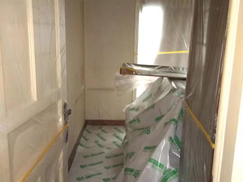 全屋家具成品保護：滿鋪成品瓦楞紙板，再用干凈彩條布滿鋪在普通石膏板上，在彩條布交接處及轉(zhuǎn)角處用膠帶固定，也可選用木芯板或三夾板。材料選用視上人、車情況而定。 所有成品飾面板在安裝好后必須用PE保護膜覆蓋包起來，所有成品飾面板的陽角位必須用硬質(zhì)紙護角或泡沫棉進行保護性包裝，防止交被其他施工人員碰撞。 1、入戶門扇用公司統(tǒng)一的門貼進行全面包裹保護，用透明膠帶將保護膜粘貼牢固平整。 2、用標準保護膜將門框三面保護完整并固定牢固。 3、工程完工后拆除保護膜時如果有粘貼時的膠痕，應用酒精或?qū)Ｓ玫那逦蹌┣宄z痕。