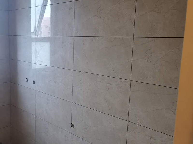 地磚墻磚鋪貼方案：在鋪貼墻磚之前，需要對(duì)其進(jìn)行基層處理。先將基層表面的灰塵和污漬清理干凈，然后在將其表面的膩?zhàn)訉雍屯苛蠈尤コ蓛?。同時(shí)，還應(yīng)對(duì)基層的平整度進(jìn)行檢查，如果基層不平，則還需要用水泥砂漿找平，否則會(huì)影響墻磚的鋪貼效果?；鶎忧謇砀蓛艉螅€不能直接鋪設(shè)墻磚，而是要先在墻體四周用墨線彈出幾條標(biāo)高控制線，并在地面彈出十字線，控制好每塊地磚的尺寸。調(diào)制好粘結(jié)劑之后，就可以開始準(zhǔn)備鋪貼墻磚了。在鋪貼前，要對(duì)墻磚產(chǎn)品表面的灰塵和污垢進(jìn)行清理。處理干凈后，便可將事先配置好的漿料涂抹在瓷磚背面，注意在涂抹漿料的時(shí)候要涂的均勻和飽滿。將涂抹了漿料的墻磚按照之前預(yù)鋪的花紋樣式進(jìn)行鋪貼，鋪貼平整之后，再用橡膠錘子將其拍平鋪實(shí)，增強(qiáng)其穩(wěn)定性。同時(shí)，在這個(gè)過(guò)程中，還可稍微的轉(zhuǎn)動(dòng)一下墻磚，讓瓷磚背面與漿料充分接觸，緊密融合。