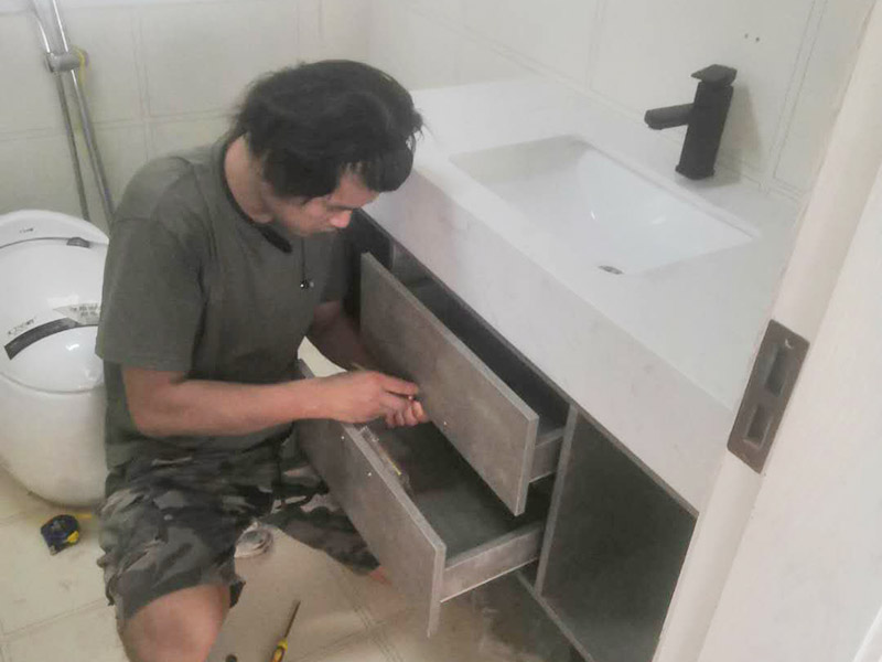 浴室柜及燈具安裝：安裝前，檢查零配件是否齊全。安裝三角閥，確保冷熱進(jìn)水管保持齊平。測(cè)量距離，安裝下水管。涂抹膠水要均勻，確保管與管間連接緊密。安裝柜角，看所有角是否在同一水平。裝好后可做適當(dāng)?shù)恼{(diào)整。將浴室柜靠墻放好。看進(jìn)出水管位置是否得當(dāng)，不合適時(shí)需做一定改動(dòng)。安裝臺(tái)盆的龍頭。龍頭最好與浴室柜配套購(gòu)買，這樣出水角度較為適合。用螺母固定臺(tái)盆龍頭。固定時(shí)一只手要扶好龍頭，以免裝好后位置偏離。將裝好龍頭的臺(tái)盆放在浴室柜上，調(diào)整位置到最佳為止。連接臺(tái)盆的進(jìn)出水管及下水，長(zhǎng)度適當(dāng)，位置合理。裝好柜體的把手，并進(jìn)行適