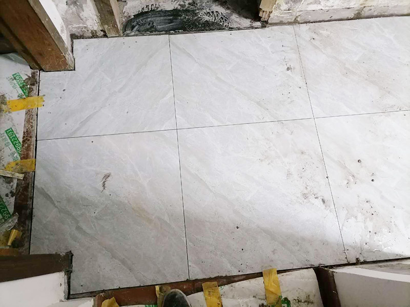 走廊地面貼磚案例:首先，要先清理現(xiàn)場，先灑適量的水以利施，在施工地面撒上水泥粉，以掃把撥弄均勻，以增加與水泥沙漿的粘著性，在施工地點測出水平落差最高的地方：首先在每一面的墻上，分別測出其水平線。 然后，以每一面墻的水平落差的最高點基準，以水泥沙漿為標記，做為打底的水平基準，將水泥與沙以1：3的比例混合成水泥沙漿，以約六尺的木尺打底，徹底抹平，拉放樣線，再次撥灑水泥粉，以增加瓷磚的粘著性，在貼瓷磚的過程中，一方以槌柄輕敲瓷磚，讓它能確實吃漿。另一方面，并以水平尺測量，確保瓷磚水平，貼完之后，先以海綿沾水將瓷磚擦干凈。