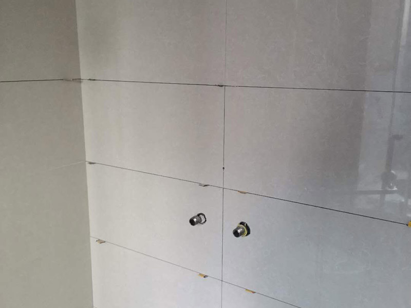 瓷磚空鼓維修鋪貼：首先，先使用空鼓錘敲擊墻面確認(rèn)空鼓范圍。如果敲擊的聲音比較沉悶的話，說明鋪貼比較實也比較牢固。反之，發(fā)出&ldquo;咚咚&rdquo;清脆的聲響的話，說明瓷磚存在空鼓。然后在開孔處注射瓷磚空鼓修復(fù)膠。如有溢出的膠水盡量在干固之前用濕抹布擦掉，如填縫處有膠水滲出是因為原有的填縫劑密度不夠，可重新涂抹一層密度較大的填縫劑。最后使用填縫劑填補孔位，擦掉多余的填縫劑。