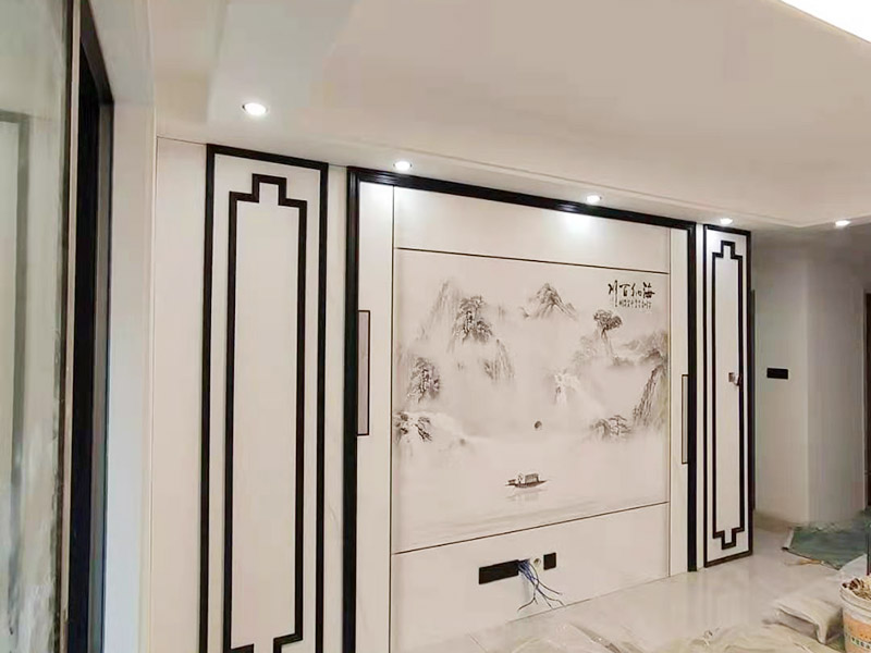 客廳背景墻安裝：在安裝護墻板前，首先對背景墻除塵和找平處理，以保證基層光滑平整且無顆粒等臟物。以確保墻板安裝時的平穩(wěn)度和牢固度。開始根據電視背景墻的尺寸切割墻板，若護墻板需做整面墻，切割時一定要注意長寬尺寸的精確度，切記偏差不可過大。開始安裝，順序是由下至上，由左至右，并距離板塊上端1.5CM左右，用膨脹螺絲將其固定住，同時注意不要露出護墻板表面，否則影響美觀度。將墻板全部安裝好后，直接使用專用膠來固定便可。 在安裝過程中要注意墻板紋飾顏色是否一致，保持分隔線一致、順暢，不可錯亂，否則會拉低整個電視背景墻的美觀度。安裝好后對拉縫處安裝壓條，增強裝飾效果。