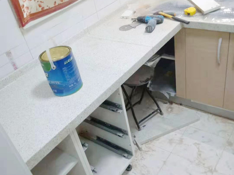 櫥柜維修改造：對(duì)廚房作防護(hù)措施,掛擋布、廚房墻面等做簡(jiǎn)單清理,以便準(zhǔn)確測(cè)量地面水平。 材料進(jìn)場(chǎng):櫥柜板材等進(jìn)場(chǎng)。  安裝地柜 組裝:統(tǒng)一組裝好地柜,搬進(jìn)廚房,按圖紙順序擺放好位置(倒放),統(tǒng)一安裝地腳。 現(xiàn)場(chǎng)切割:地面上墊上保護(hù)物,割口根據(jù)實(shí)物的大小從反面進(jìn)行操作,保持正面不崩。 安裝順序：如有轉(zhuǎn)角柜應(yīng)先安轉(zhuǎn)角柜，沒有轉(zhuǎn)角柜先從靠墻的柜往外安裝。 水平調(diào)整：通過地柜的調(diào)節(jié)腿調(diào)節(jié)地柜水平度，誤差保持正負(fù)1mm。