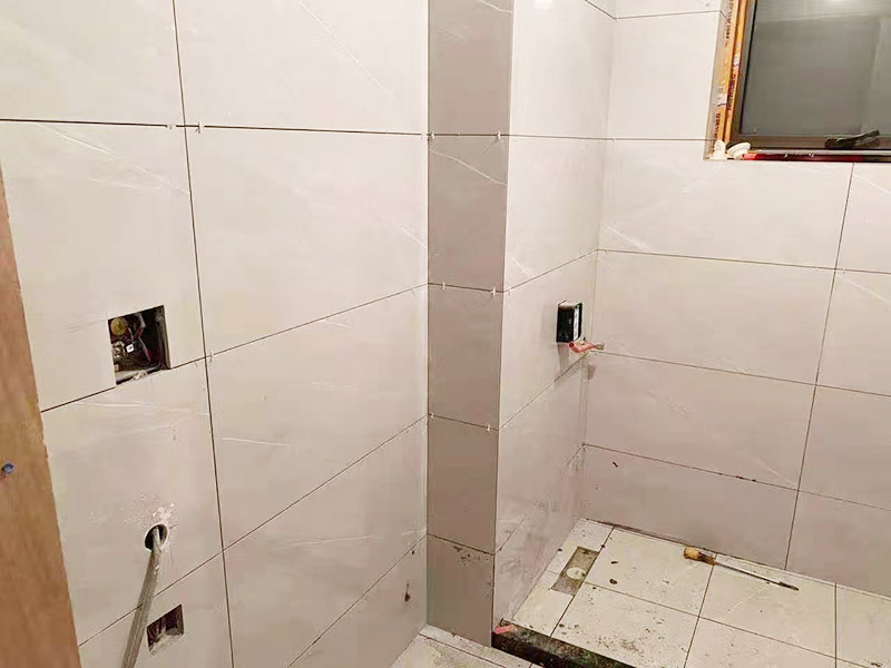 衛(wèi)生間貼磚施工：衛(wèi)生間貼磚要先將所需材料準備好，一般用在這個空間的話可以選擇小瓷磚，例如小方塊類型的瓷磚就不錯，貼起來也比較方便。然后將水泥與建筑膠混合拌勻，用鏟刀將其鏟到地面刮平再將瓷磚鋪上刀壓實，這樣按照這樣的方式自上而下或自左而右來進行貼磚即可。