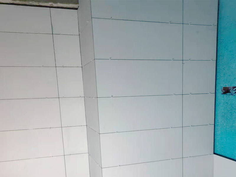 衛(wèi)生間貼磚施工：很多人都知道瓷磚在鋪貼前都要經(jīng)過(guò)泡水，一般把需要鋪貼的瓷磚放入水中浸泡半個(gè)小時(shí)左右，這樣瓷磚充分吸收水份后便于跟水泥相粘合，墻面更加牢回。 瓷磚鋪貼前一定要對(duì)墻面進(jìn)行檢查，看看有沒(méi)有裂縫需要修補(bǔ)，如果有膩?zhàn)臃蹧](méi)有清除直接貼磚，會(huì)產(chǎn)生后期的瓷磚脫落。 瓷磚鋪貼時(shí)一定要選擇正確的水泥標(biāo)號(hào)和調(diào)配水泥沙子的混合比例，水泥比例越高，瓷磚黏結(jié)力越強(qiáng)，但水泥混合比例高，會(huì)導(dǎo)致水泥沙漿的膨脹系數(shù)增大，容易造成瓷磚鋪貼后將磚擠裂。