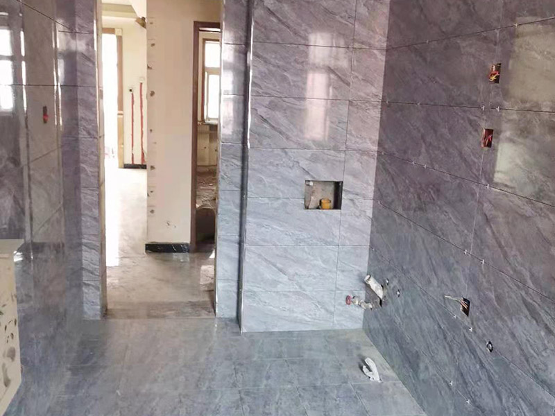 全屋瓷磚鋪貼：首先應(yīng)除去基層表面的污垢，油漬，浮灰;除去基層上所有涂料層，膩?zhàn)訉?如果基層未能達(dá)到平整度要求，需對(duì)基層進(jìn)行預(yù)先的找平處理。鋪貼瓷磚前需事先找好垂直線，以此為基準(zhǔn)鋪貼的瓷磚高低均勻、垂直美觀;此外，施工前在墻體四周需彈出標(biāo)高控制線，在地面彈出十字線，以控制地磚分隔尺寸。加水后將粘結(jié)劑漿料攪拌至潤(rùn)滑均勻，無(wú)明顯塊狀或糊狀結(jié)塊，攪拌后的漿料靜置5-10分鐘后再稍加攪拌1-2分鐘即可使用。將瓷磚平整地鋪貼在基層上，使用橡膠錘將瓷磚拍實(shí)鋪平。施工過(guò)程中，可小幅度轉(zhuǎn)動(dòng)瓷磚，使?jié){料與瓷磚背面充分接觸。