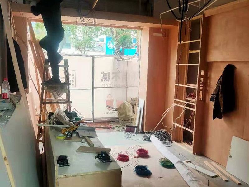 門店木工施工現(xiàn)場(chǎng):首先應(yīng)該搭建木作施工臺(tái)。木作施工臺(tái)用于板材的切割板，板材的造型，板材的平整度處理等等。門窗的制作包括門窗套制作、門窗制作。要特別注意門窗扇與框之間的縫隙不能太大，以及門窗套與門窗的色差等。木作表層封裝木制品制作完成后，對(duì)其表面進(jìn)行細(xì)節(jié)封裝。木作表層封裝通常就要用到各種各樣的家裝板材，特別注意板材的選購。