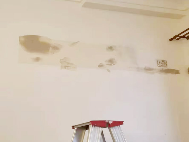 墻面刷新烤燈處理：施工前用塑料保護膜將室內(nèi)的地板覆蓋、家居包裹、電源插座覆蓋；并用膠帶貼牢。對基層原有涂層應(yīng)視不同情況區(qū)別對待：疏松、起殼、脆裂的舊涂層應(yīng)將其鏟除;粘附牢固的舊涂層用砂紙打毛;不耐水的涂層應(yīng)全部鏟除。清除基層表面塵土和其它粘附物。較大的凹陷應(yīng)用聚合物水泥砂漿抹平。并待其干燥。較小的孔洞、裂縫用水泥乳膠膩子修補。 墻面泛堿起霜時用硫酸鋅溶液或稀鹽酸溶液刷洗，油污用洗滌劑清洗，最后再用清水洗凈。