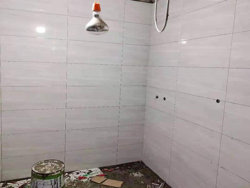 浴室貼磚裝修:把還沒有涂抹水泥的地磚鋪在地上，把它們敲平，然后在地磚上涂滿水泥，鋪在地面，保持四塊磚的對角位置對齊。 鋪瓷磚的順序其實也是有不少講究的，鋪地磚的時候應(yīng)該從內(nèi)向外貼，遇到坡度或者有地漏的地方，還要注意排水方向找坡；墻面磚的鋪貼應(yīng)該從下向上進(jìn)行。為了最后的鋪貼效果美觀，最底層的瓷磚要最后貼；墻面磚鋪貼結(jié)束以后還要壓地磚。 這里要注意的是，貼瓷磚的時候不能一面墻貼到頂，否則由于瓷磚較重容易引起脫落。鋪好了地磚盡量不要去踩。 因為瓷磚本身有許多小孔，吸水能力強(qiáng)，干燥的瓷磚會吸干水泥的水分.