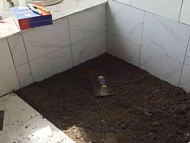 地面貼磚施工：鋪貼前，先將所鋪平面表面的塵土、雜物等徹底清掃干凈，平面不能有空鼓、開裂和起砂等現(xiàn)象，如果存在這些現(xiàn)象，要先進行修復(fù)處理，在鋪設(shè)瓷磚。瓷磚的鋪貼，要選用1:3干硬性水泥砂漿，砂漿的厚度要在25mm左右。把瓷磚按照要求放在水泥砂漿上，用橡皮錘輕輕敲擊瓷磚的表面，直至瓷磚鋪貼平整。鋪貼完瓷磚后，要進行勾縫處理，先清理干凈瓷磚縫隙里的雜質(zhì)，再用專用填縫劑進行勾縫處理。鋪貼瓷磚的過程中，可以一邊鋪貼，一邊進行簡單的清理。在鋪貼完24小時后，再用棉布等對瓷磚的表面再進行一次清理。