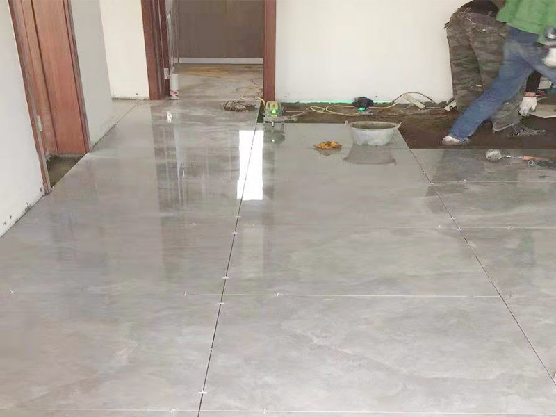 客廳地面貼磚：首先要把基層用水澆濕，除去雜物和浮沙。再抹結(jié)合層，需要注意的是要使用1：3的干性水泥漿，按照水平線探鋪平整，然后再把磚放在沙漿上用膠皮錘振實(shí)。這時(shí)再把地面磚取下澆抹水泥漿，然后把地面磚放實(shí)振平就可以了。采用干鋪法可以有效地避免鋪裝過程中造成的空鼓、氣泡等現(xiàn)象發(fā)生。但是干鋪法的技術(shù)含量比較高，所以費(fèi)用也會(huì)比較貴。