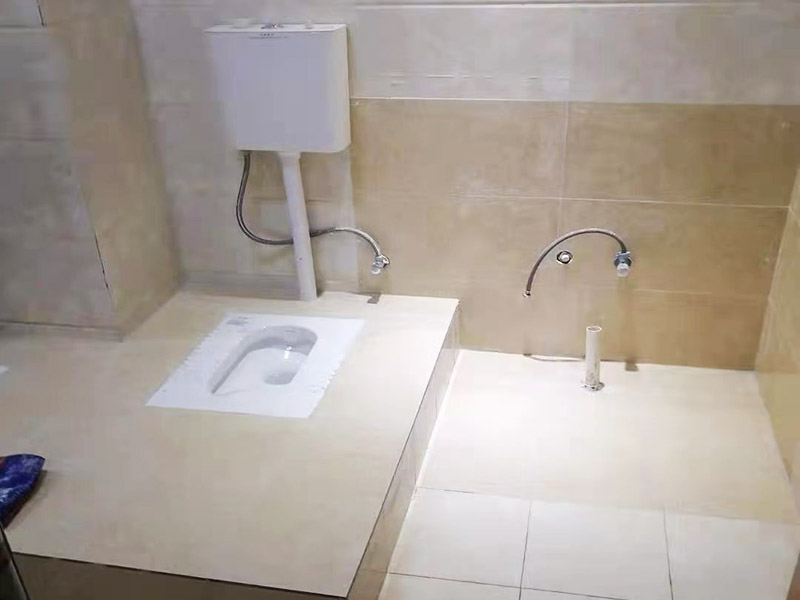 蹲便器安裝貼磚裝修：1.根據(jù)所安裝產(chǎn)品的排污口，在離墻適當(dāng)?shù)奈恢妙A(yù)留下水管道，同時(shí)確定下水管道入口距地平面的距離。 2.在地面下預(yù)留安裝蹲便器的凹坑深度大于便器的高度。 3.將連接膠塞放入蹲便器的進(jìn)水孔內(nèi)卡緊。在與蹲便器進(jìn)水孔接觸的外邊緣涂上一層玻璃膠或油灰，將進(jìn)水管插入膠塞進(jìn)水孔內(nèi)，使其與膠塞密封良好，以防漏水。 4.在蹲便器的出水口的邊緣涂上一層玻璃膠或油灰，放入下水管道的入口旋合，用焦渣或其它填充物將便器架設(shè)水平。 5.打開進(jìn)水系統(tǒng)，檢查各接合處有無漏水情況，若出現(xiàn)漏水，則要檢查各接合處的情況。直至問題解決。 6.檢查各接合處無漏水情況后，用填充物將便器周圍填實(shí)，同時(shí)陶瓷與水泥砂漿的接觸面填上 1cm 以上的瀝青或油氈等彈性材料。 7.用水泥砂漿將蹲便器固定在水平面內(nèi)，平穩(wěn)、牢固后，然后在水泥面上鋪貼衛(wèi)生間地磚。 8.試沖水，若無異常即可使用。