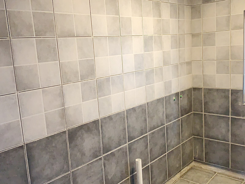 衛(wèi)生間墻磚鋪貼：首先應(yīng)除去基層表面的污垢，油漬，浮灰;除去基層上所有涂料層，膩子層;如果基層未能達到平整度要求，需對基層進行預(yù)先的找平處理。鋪貼瓷磚前需事先找好垂直線，以此為基準鋪貼的瓷磚高低均勻、垂直美觀;此外，施工前在墻體四周需彈出標高控制線，在地面彈出十字線，以控制地磚分隔尺寸。調(diào)制粘結(jié)劑：加水后將粘結(jié)劑漿料攪拌至潤滑均勻，無明顯塊狀或糊狀結(jié)塊，攪拌后的漿料靜置5-10分鐘后再稍加攪拌1-2分鐘即可使用。 將瓷磚平整地鋪貼在基層上，使用橡膠錘將瓷磚拍實鋪平。施工過程中，可小幅度轉(zhuǎn)動瓷磚，使?jié){料與瓷磚背面充分接觸。